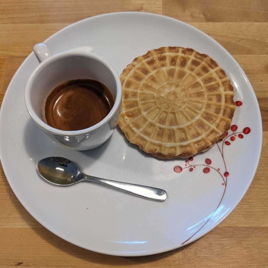 A shot of espresso with a honey caramel stroopwafel.